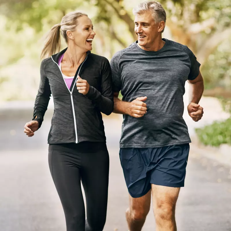 A couple goes for a run together in the Fall.