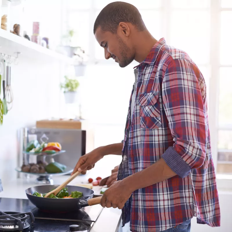 A man cooks a vegetable-based meal.