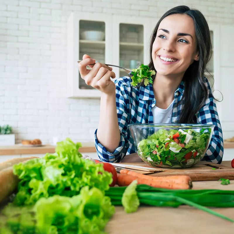 A woman eating a healthy, homemade salad. 