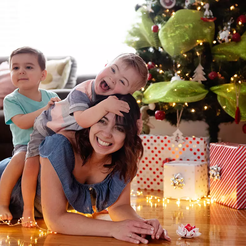 Caucasian mother with two sons laying under a Christmas tree