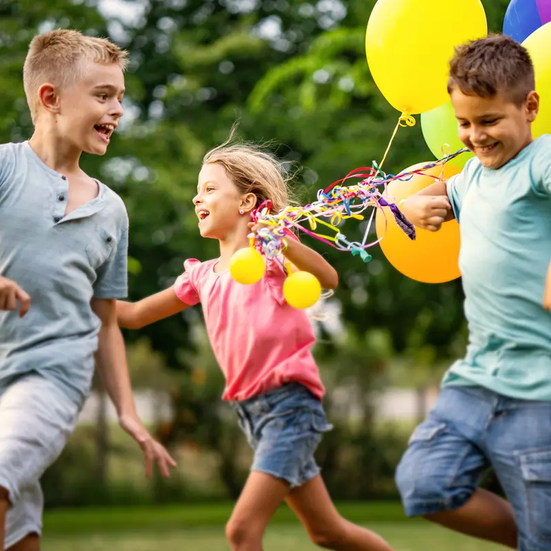 Kids running and playing with balloons