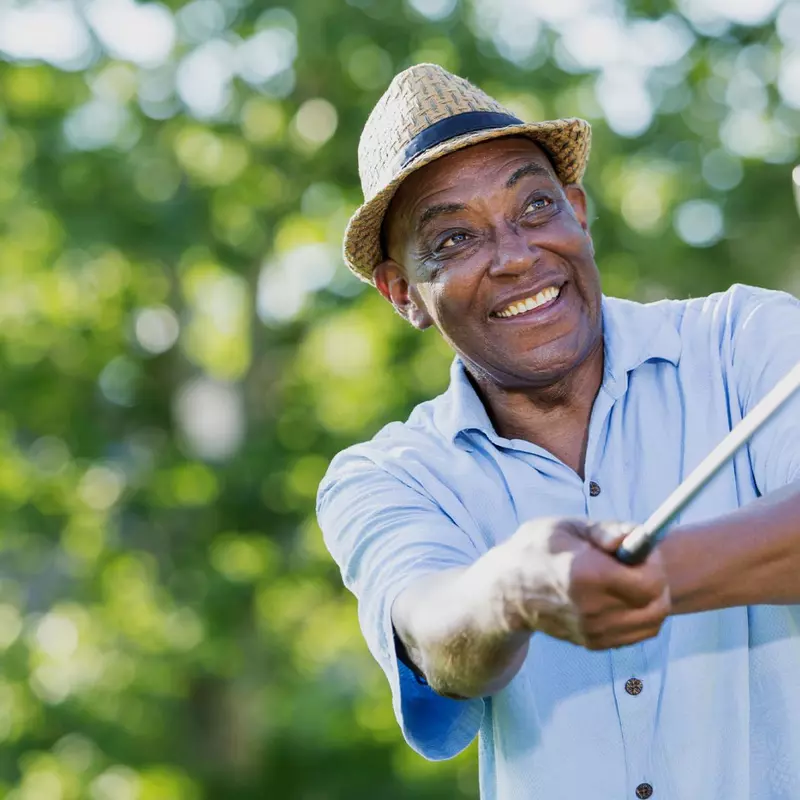 Mature golfer teeing off