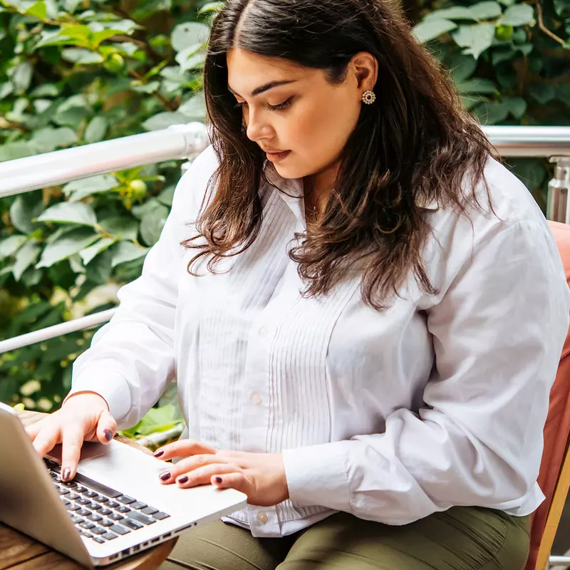 Woman on her laptop outside.