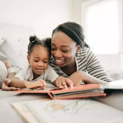 A young mother reading with her child in bed