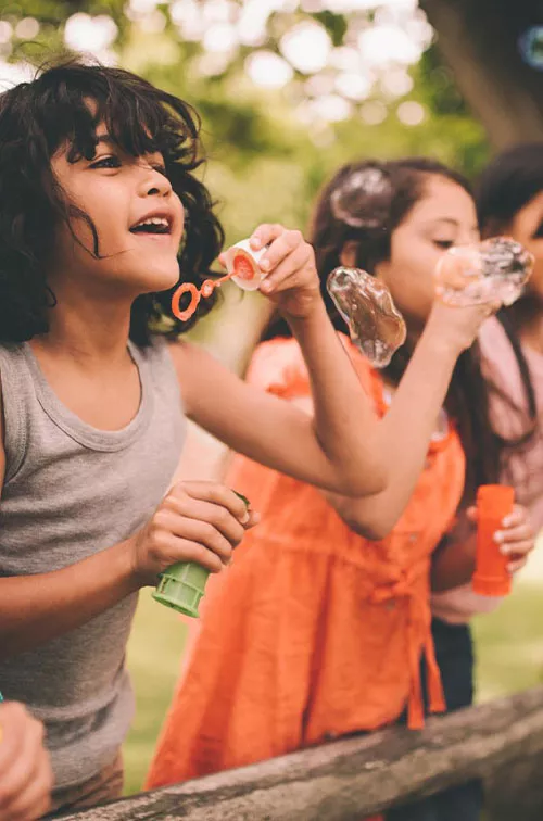 A group happy children blowing bubbles during the summer.