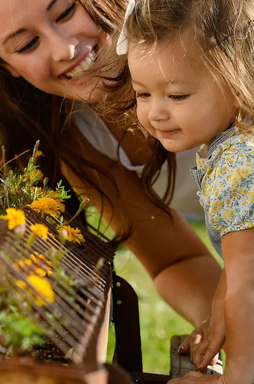 Mother and daughter smelling flowers. 