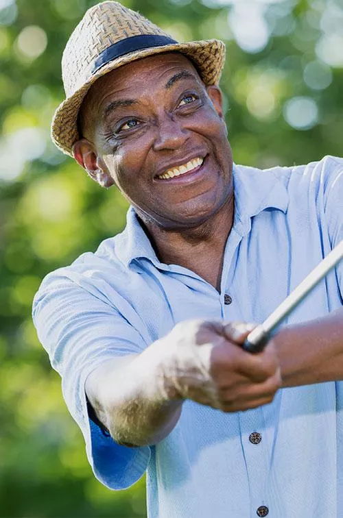 Mature golfer teeing off