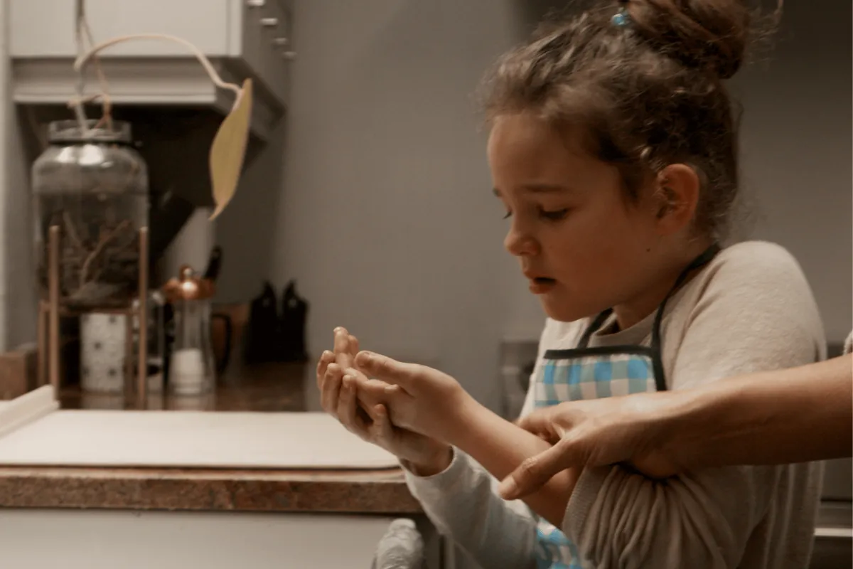 Child examining a burn in the bathroom with parent